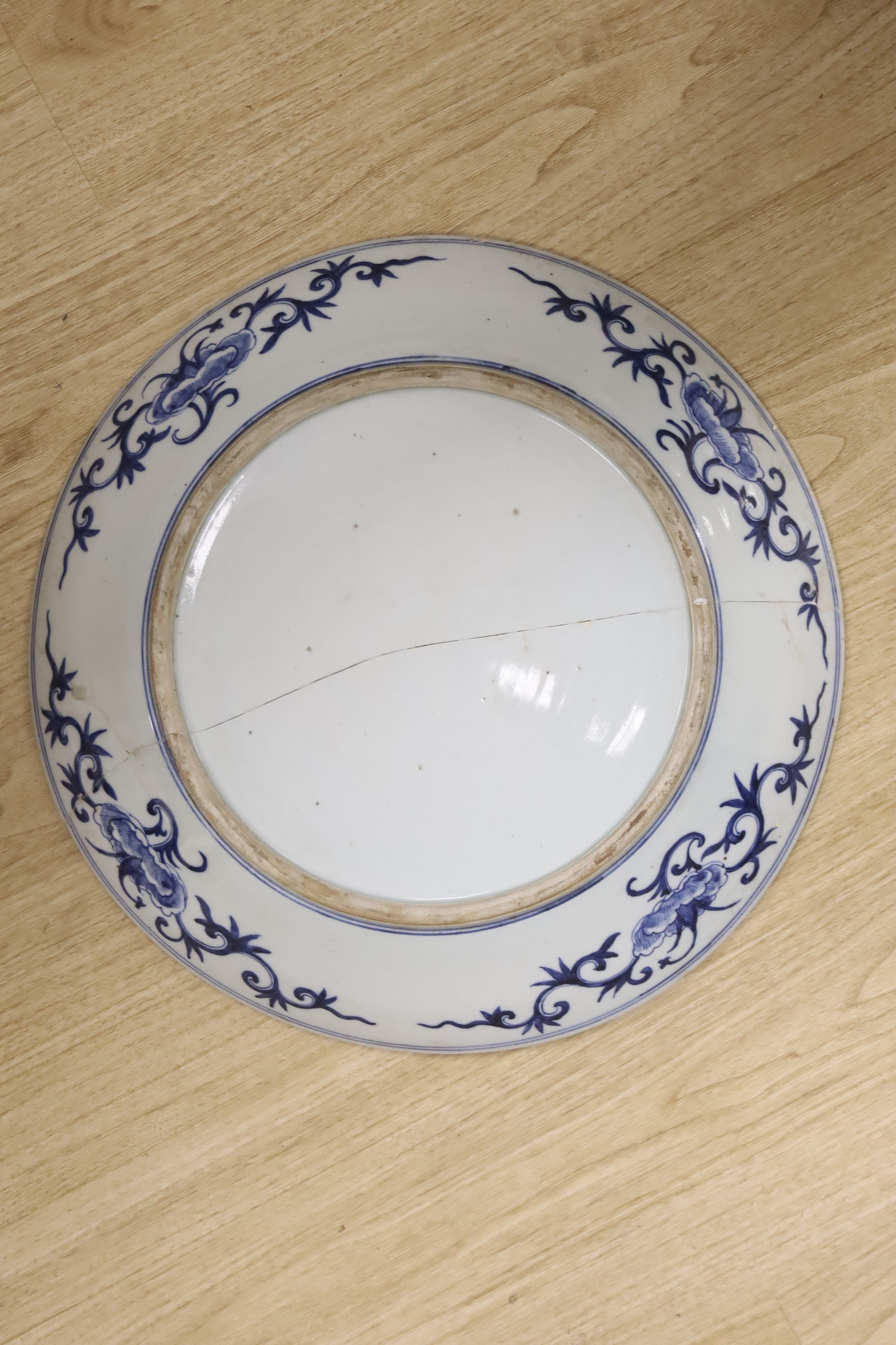A large Chinese blue and white 'lotus and eight Buddhist emblems' dish, Daoguang period, repaired. 46cm